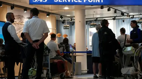 Passagiere stehen am Flughafen in Kopenhagen zum Einchecken an: 200 Flugzeug-Mechaniker wollen sich am Donnerstag dem Streik der SAS-Piloten anschließen. (Foto: Sergei Grits/AP/dpa)