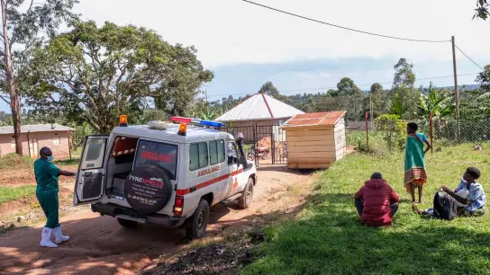 Ein medizinischer Mitarbeiter der Uganda Red Cross Society fordert Menschen mit Verdacht auf eine Ebola-Erkrankung dazu auf, in einen Krankenwagen einzusteigen. (Foto: Hajarah Nalwadda/AP/dpa)