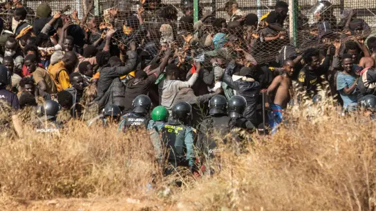Migranten kommen auf spanischem Boden an, nachdem sie die Zäune zwischen der spanischen Exklave Melilla und Marokko überquert haben. (Foto: Javier Bernardo/AP/dpa)