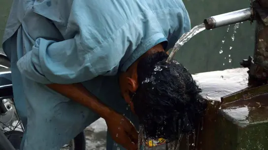 Ein junger Mann in Pakistan erfrischt seinen Kopf unter einem Wasserhahn. (Foto: Ppi/PPI via ZUMA Press Wire/dpa)