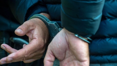 Ein Mann trägt Handschellen. (Foto: Stefan Sauer/dpa/Illustration)