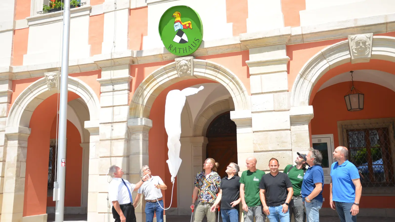 Groß war die Freude, als die Hülle des Stadtwappens am Rathaus fiel. Bürgermeister Klaus Meier (links) atmete auf, denn es lief alle reibungslos. Peter Pabst (Zweiter von links) hatte das Stadtwappen bemalt. (Foto: Christa Frühwald)