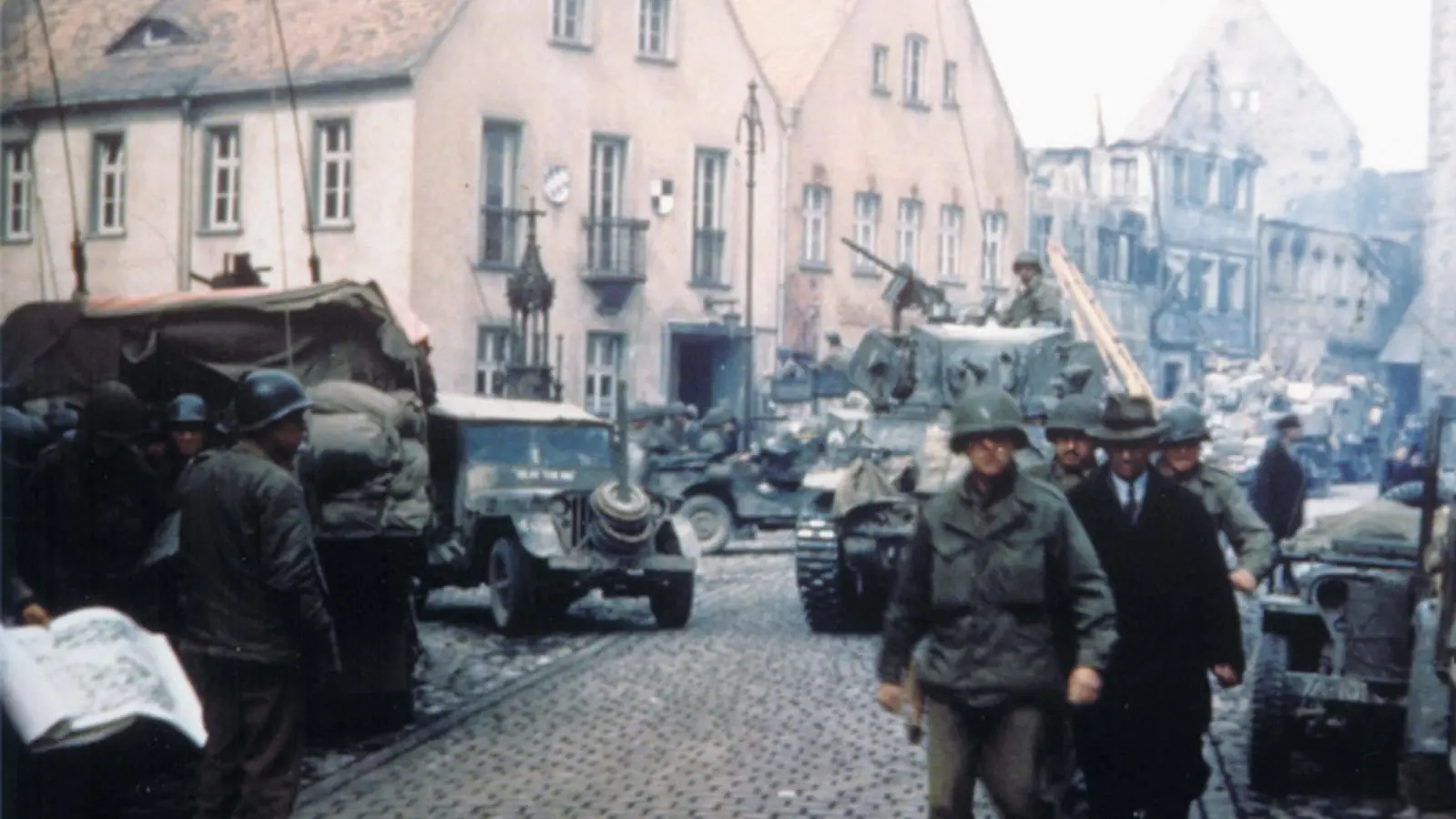 Bürgermeister Georg Schiller (rechts vorne, mit Hut) geht am 19. April 1945 mit drei US-Soldaten durch die Stadt: Diese Szene hielt ein Amerikaner mit der Kamera fest. Aus einem Archiv in den USA gelangte dieses bislang unbekannte Foto unlängst nach Leutershausen. (Foto: Captain Raymond Ebbage)