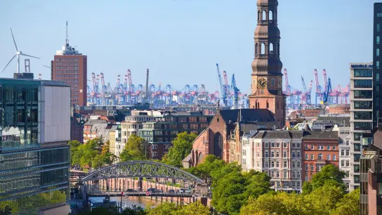 Blauer Himmel über Hafenkränen, Hauptkirche St. Michaelis und weiteren Wohn- und Geschäftsgebäuden in der Altstadt von Hamburg. (Foto: Jonas Walzberg/dpa)