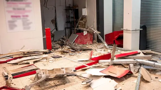 Teile eines gesprengten Geldautomaten und einer Bankeinrichtung liegen in einem Einkaufszentrum in Oststeinbek. (Foto: Daniel Bockwoldt/dpa)