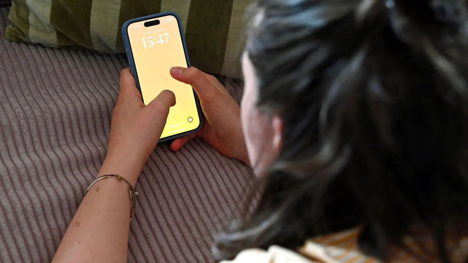 Zum Schutz vor Stalkerware sollte das Smartphone immer - auch daheim - mit einer starken Bildschirmsperre gesichert werden. (Foto: Elisa Schu/dpa/dpa-tmn)