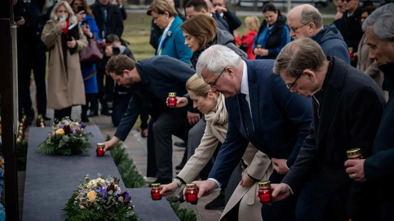 Kerzen und stille Andacht: Am vierten Jahrestag der Befreiung der ukrainischen Kleinstadt Butscha von russischen Besatzungstruppen gedenken Außenminister Johann Wadephul (r., CDU) und andere EU-Spitzenpolitiker gemeinsam mit dem ukrainischen Außenminister Andrij Sybiha (m.) der Opfer.  (Foto: Eduard Khryzhanivsky/Ukrainian Foreign Ministry Press Office/AP/dpa)
