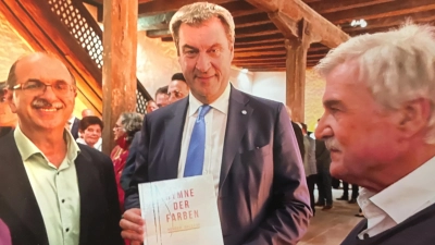 Bei einem Empfang für Ehrenamtliche 2024 in Nürnberg ist auch Ministerpräsident Markus Söder (Bildmitte) vom Engagement von Moneer Ballish (links) zufrieden. Hans Emmert (rechts) unterstützt Ballish bei seinen Kunstprojekten. (Foto: Elisabeth Emmert-Löblein)