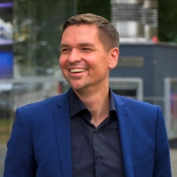 Der neue Schauspielleiter Bartholomäus Pakulski vor der gläsernen Fassade des Theater Ansbach: Das Programm seiner ersten Spielzeit steht unter dem Motto „Ankommen”. (Foto: René Chlopotowski)