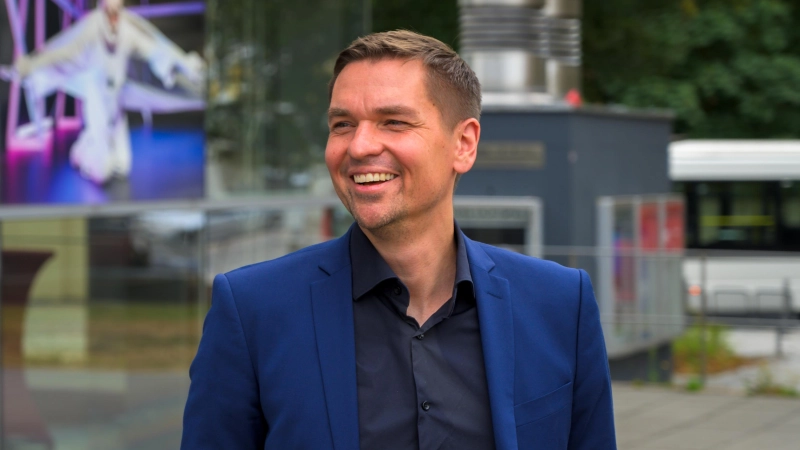 Der neue Schauspielleiter Bartholomäus Pakulski vor der gläsernen Fassade des Theater Ansbach: Das Programm seiner ersten Spielzeit steht unter dem Motto „Ankommen”. (Foto: René Chlopotowski)