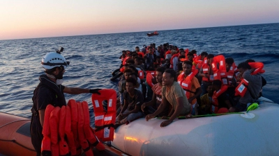 Die Besatzung der Sea-Watch 3 verteilt Rettungswesten an Menschen in einem Schlauchboot, mit dem sie versuchten nach Europa zu gelangen. (Foto: Nora Boerding/Sea-Watch via AP/dpa)