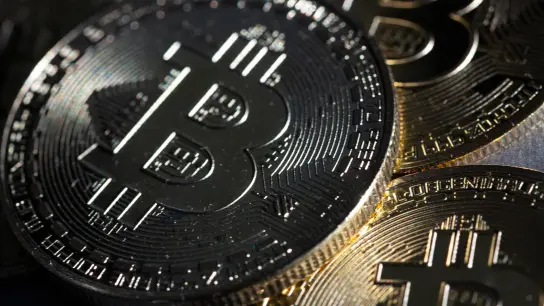 Bitcoin-Münzen liegen auf einem Tisch. (Foto: Fernando Gutierrez-Juarez/dpa-Zentralbild/dpa)