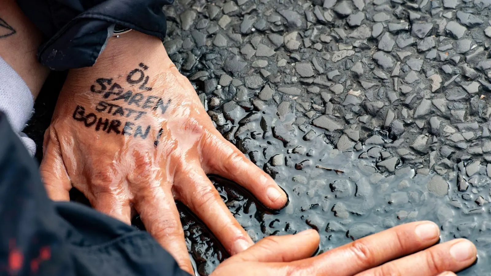 „Öl sparen statt bohren“ steht auf der Hand einer Demonstrantin der Gruppe „Letzte Generation“. (Foto: Paul Zinken/dpa/Symbolbild)