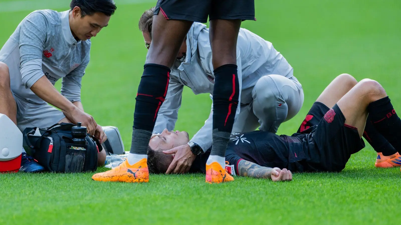 Bayer Leverkusens Kapitän Alejandro Grimaldo liegt nach einem Zusammenprall auf dem Boden.  (Foto: Rolf Vennenbernd/dpa)