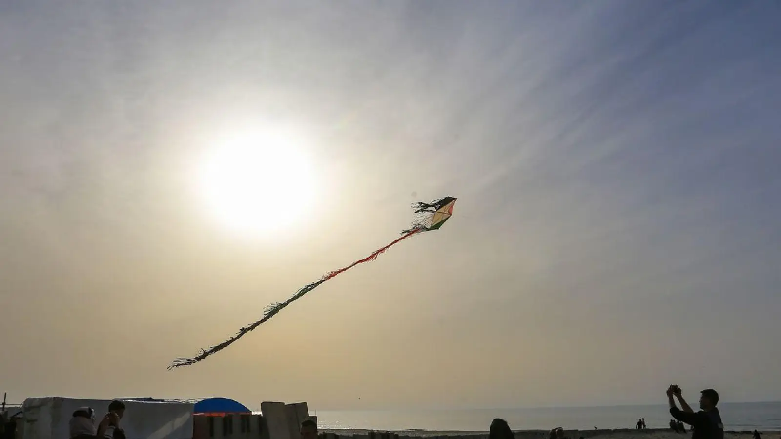 Ein wenig Normalität im Ausnahmezustand: Diese Palästinenser vergessen vielleicht für einen Moment die Schrecken ihres Alltages und lassen eine Drachen am Strand von Chan Junis steigen. (Foto: Mohammed Talatene/dpa)