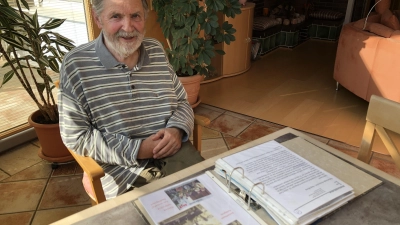 Rainer Arnold vor einem Ordner mit Erinnerungen aus fast 60 Jahren Musikerleben. Er hat auf vielen Bällen und Veranstaltungen in der Region gespielt. (Foto: Johannes Flierl)
