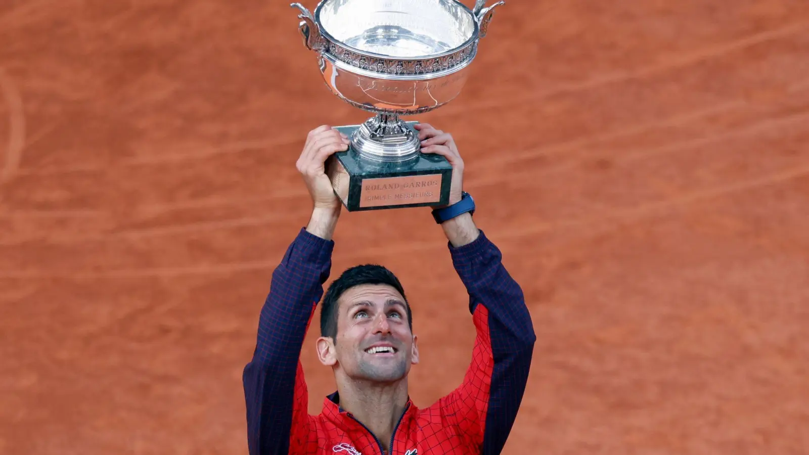 French-Open-Sieger Novak Djokovic reckt die Trophäe in die Höhe. (Foto: Jean-Francois Badias/AP/dpa)