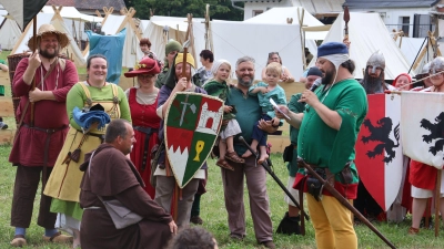 Der Vorsitzende der Keuperfelser Ritterschaft, Oliver Herold (mit Mikrofon), ernennt den Organisator und Ehrenhalber-Ritter Jürgen Ebert (kniend), zum Schutzherrn des Rimbachgrunds. (Foto: Andreas Reum)