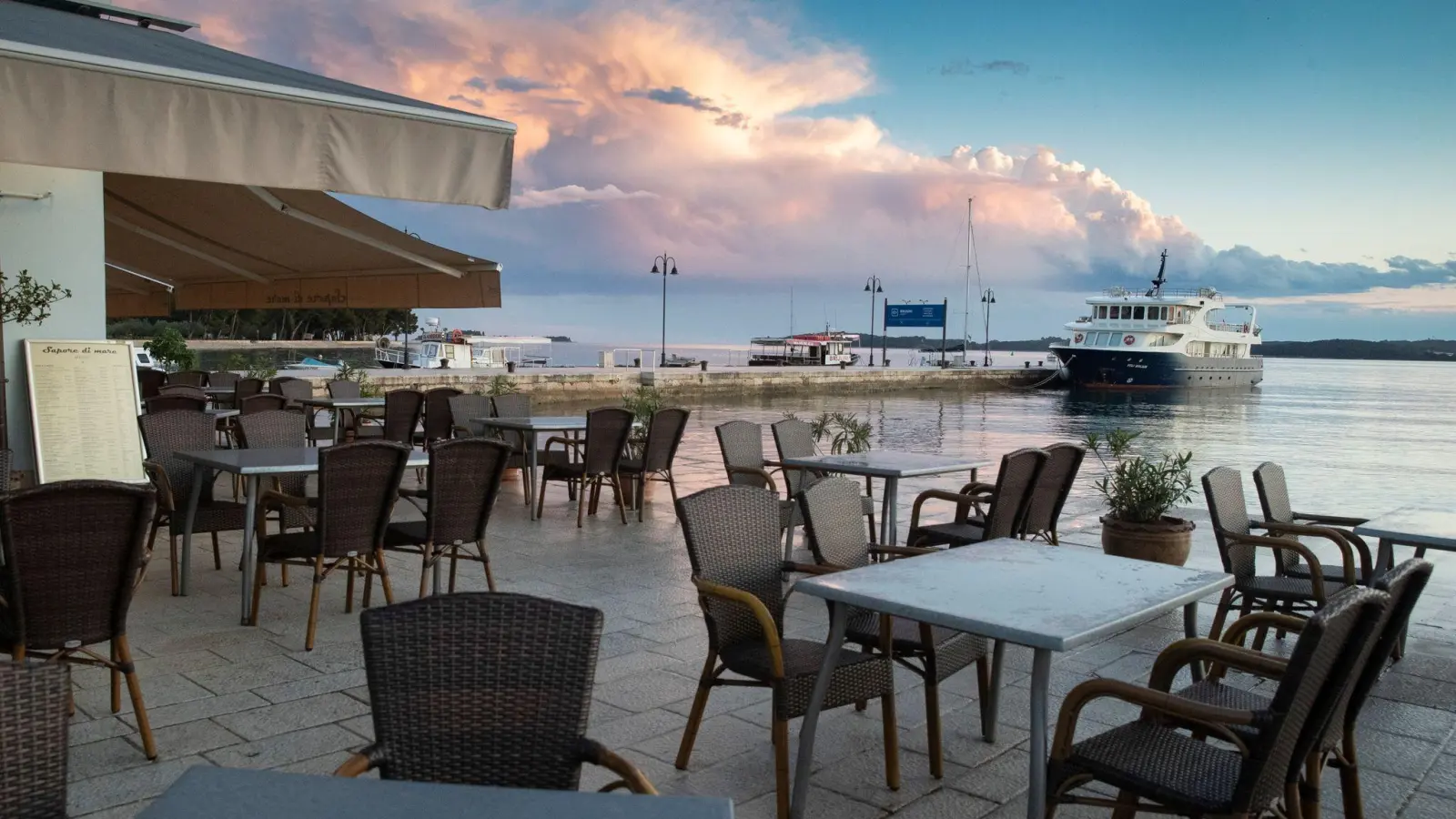 Die Tische in den Cafés und Restaurants im Hafen von Fazana: Touristen sind für Kroatien eine wichtige Einnahmequelle. (Foto: Darko Bandic/AP/dpa)