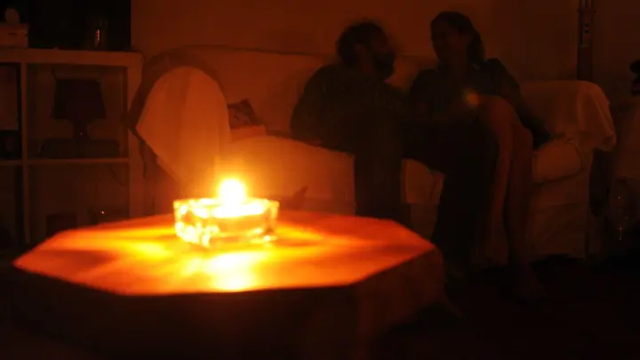 Ein Paar sitzt während eines Stromausfalls bei Kerzenschein in einer Wohnung. (Foto: picture alliance / dpa/Symbolbild)