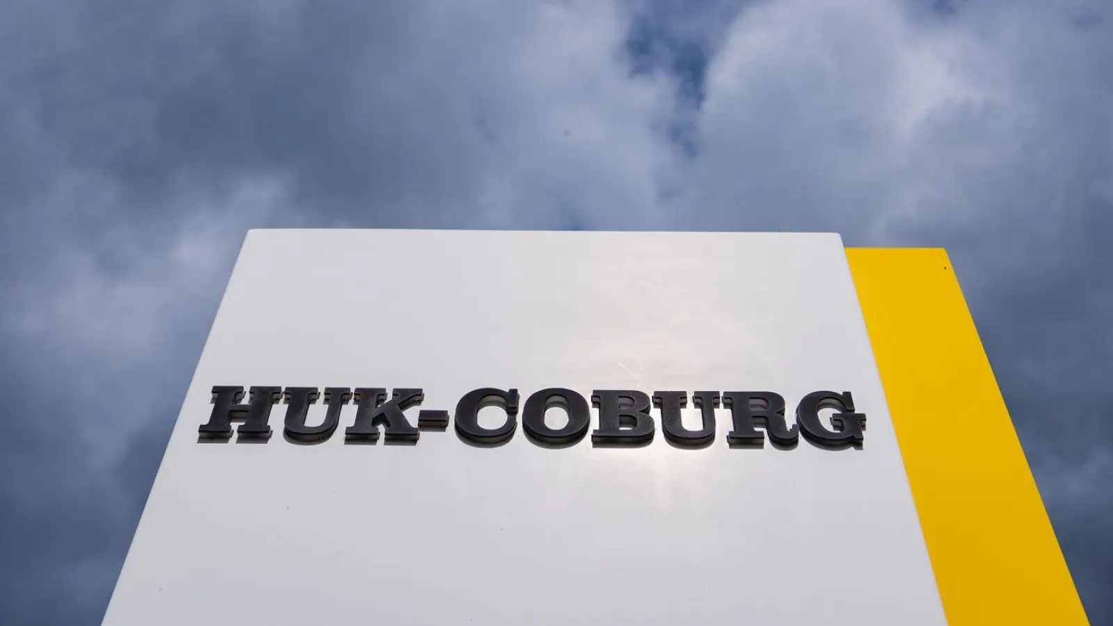 Auf einem Schild ist der Schriftzug des Unternehmens HUK-Coburg angebracht. (Foto: Nicolas Armer/dpa)