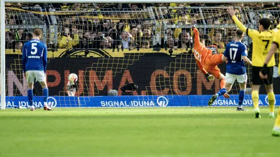 Der Ball fliegt zum Dortmunder 1:0 ins Schalker Tor. (Foto: David Inderlied/dpa)