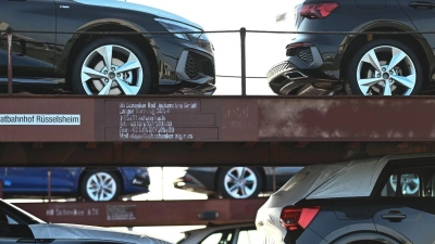 Neuwagen von Volkswagen und Audi stehen auf einem Autozug in einem Hafen. (Foto: Lars Penning/dpa/Archivbild)