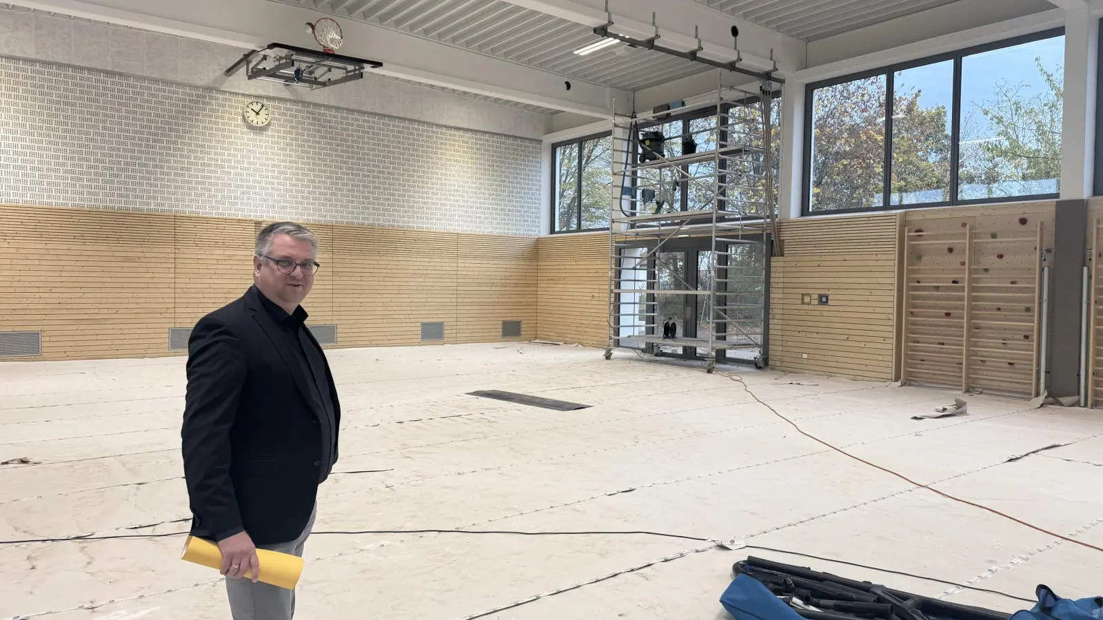 Bürgermeister Daniel Mogge auf der Baustelle: Die umfassende Sanierung der Turnhalle an der Schule in Petersaurach soll in den nächsten zwei Wochen abgeschlossen werden.  (Foto: Lara Hausleitner)