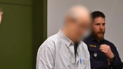 Der 70 Jahre alte Angeklagte steht vor Prozessbeginn am Landgericht München I im Gerichtssaal. Der Mann soll vor 45 Jahren einen 69-Jährigen mit einem kiloschweren Mörserstößel in dessen Badezimmer erschlagen haben, um seine Wertgegenstände zu stehlen. (Foto: Niklas Treppner/dpa)