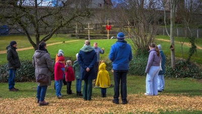 Das Kreuz ist das zentrale Symbol des Christentums und steht für den Opfertod Jesu Christi, die Verbindung zwischen dem Irdischen und dem Himmlischen sowie für Erlösung und Versöhnung. Davon erzählt Lee Koch der Gruppe, die er durch den Ostergarten führt. (Foto: René Chlopotowski)