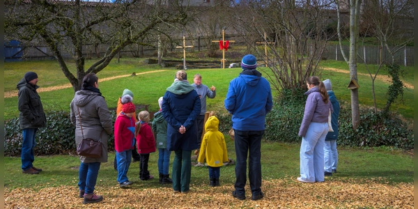 Das Kreuz ist das zentrale Symbol des Christentums und steht für den Opfertod Jesu Christi, die Verbindung zwischen dem Irdischen und dem Himmlischen sowie für Erlösung und Versöhnung. Davon erzählt Lee Koch der Gruppe, die er durch den Ostergarten führt. (Foto: René Chlopotowski)