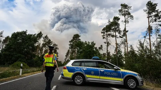 Ein Polizeiauto sperrt die Straße im Waldbrandgebiet in der sächsischen Gohrischheide ab. (Foto: Robert Michael/dpa)