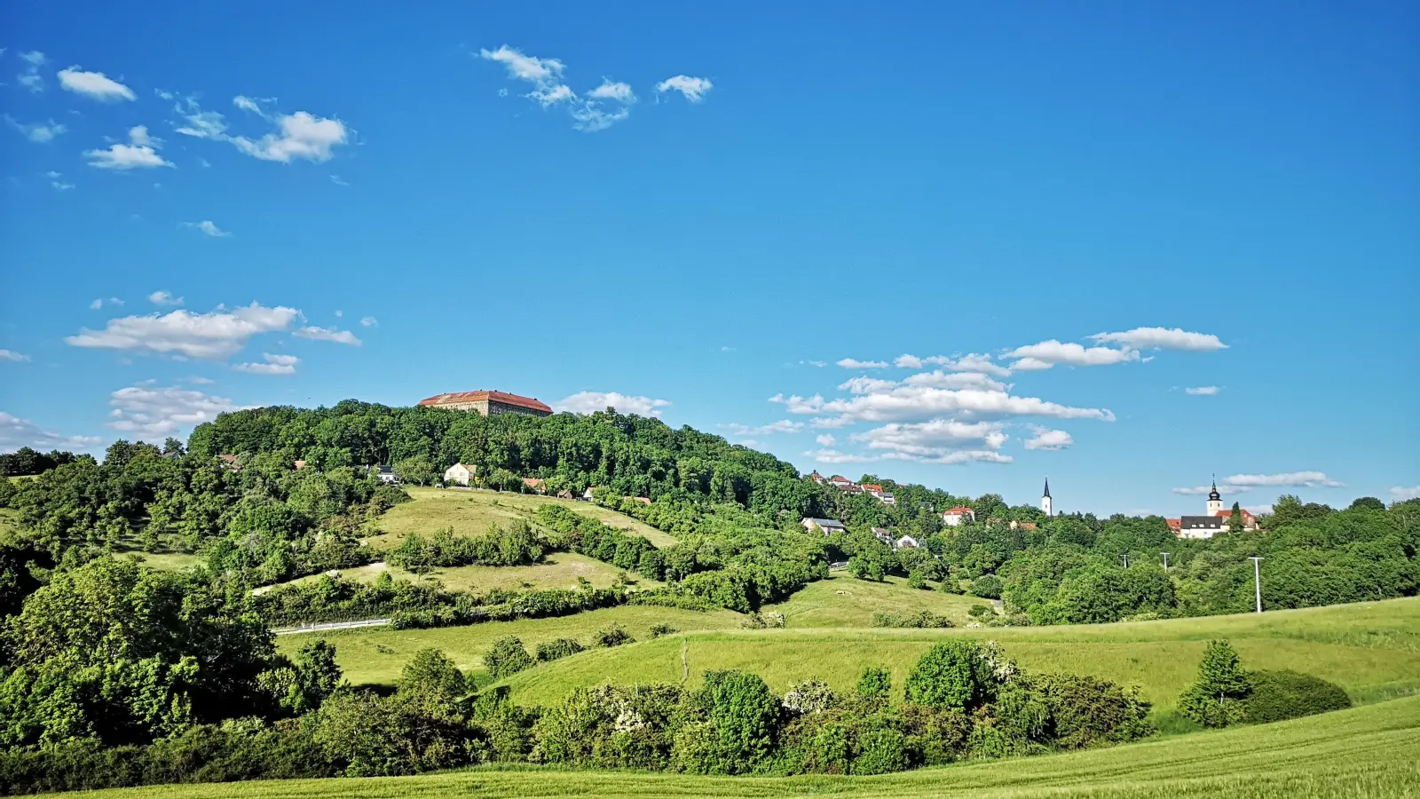 Durch seine exponierte Lage auf einem Bergsporn ist Schloss Schillingsfürst ein prägender Punkt in der Landschaft. Das Aussehen der Anlage veränderte sich über die Jahrhunderte mehrfach. Eine Vorgängerburg war heute vor 500 Jahren im Zuge der Bauernaufstände zerstört worden. (Foto: Jürgen Binder)