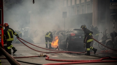 Feuerwehrleute löschen mitten in Mailand brennende Fahrzeuge. (Foto: Claudio Furlan/LaPresse via ZUMA Press/dpa)