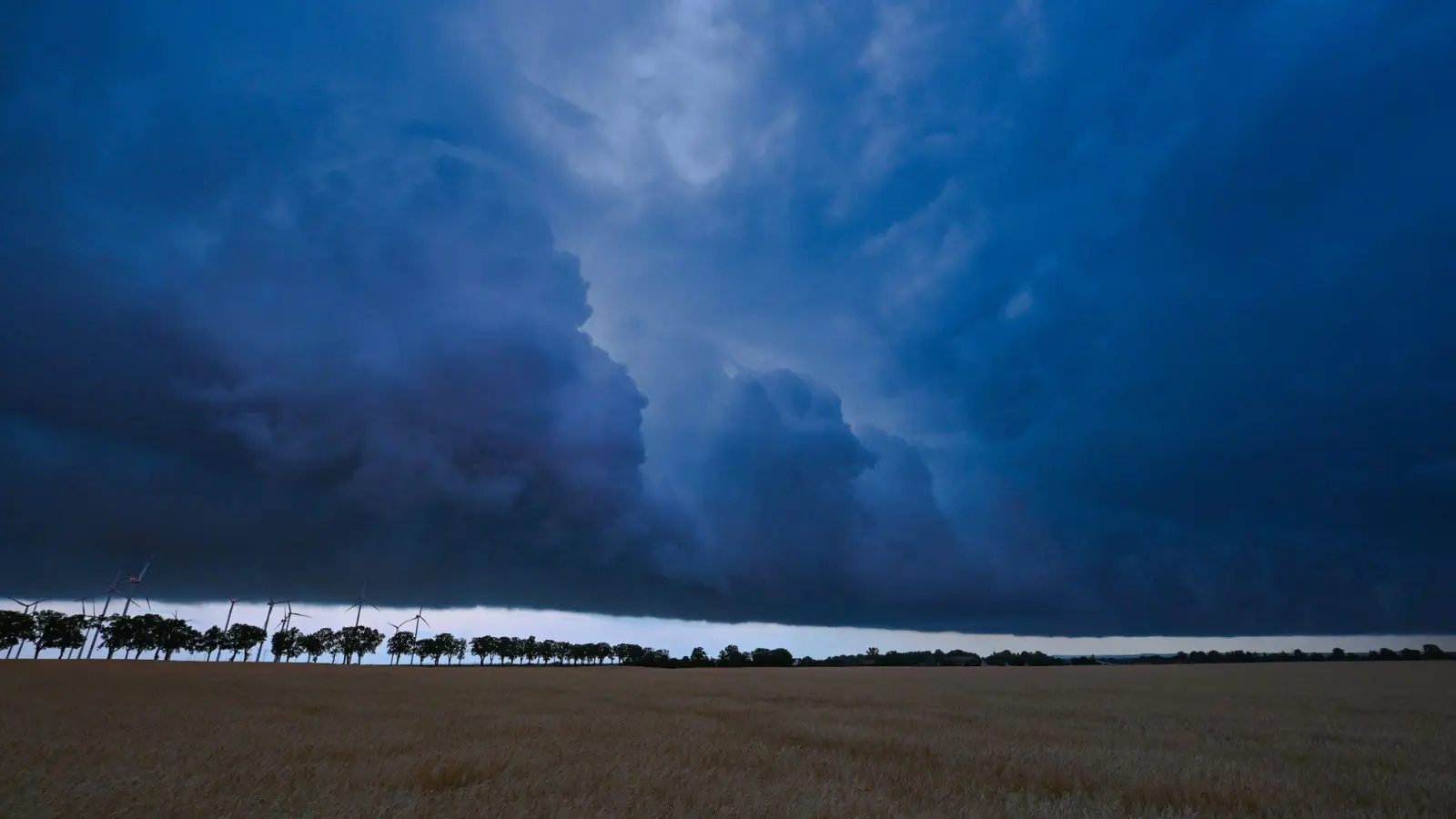 Eine Gewitterzelle zieht mit dunklen Regenwolken über die brandenburgische Landschaft. Der Deutsche Wetterdienst hat die Klima-Bilanz für das Jahr 2022 vorgestellt. (Foto: Patrick Pleul/dpa)