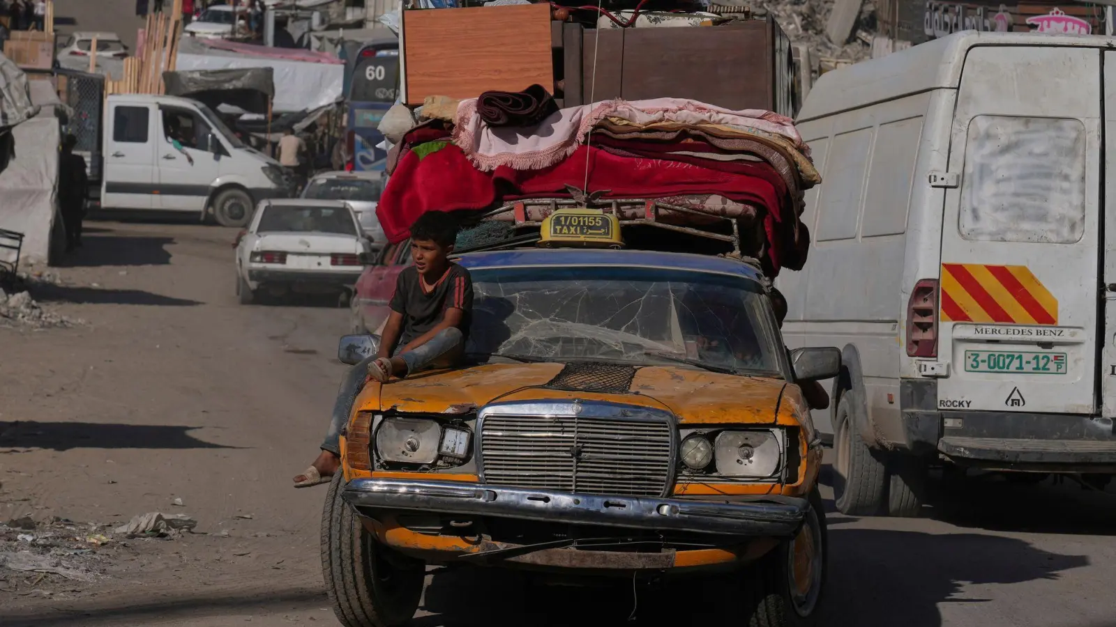 Palästinenser fliehen aus dem nördlichen Gazastreifen mit einem uralten Mercedes, auf den sie ihre Habseligkeiten geladen haben.  (Foto: Abdel Kareem Hana/AP/dpa)