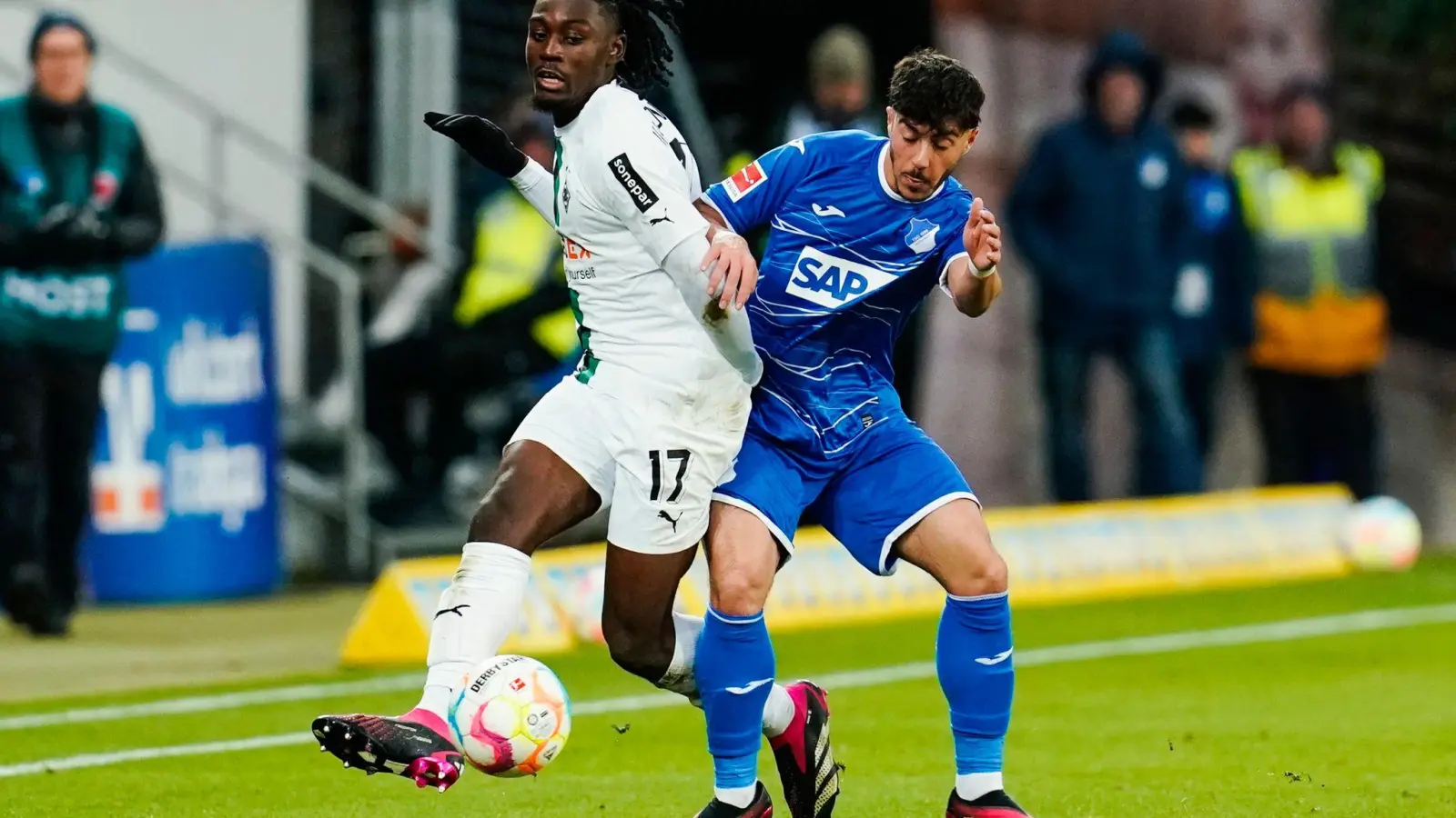Gladbachs Manu Koné (l) und Hoffenheims Umut Tohumcu kämpfen um den Ball. (Foto: Uwe Anspach/dpa)