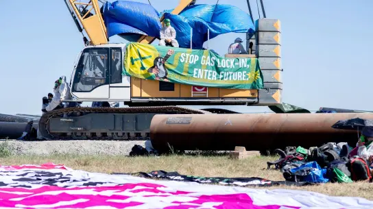 Transparent mit der Aufschrift „Stop Gas Lock-In, Enter Future.“ an einem Kran auf der Baustelle für die geplante Gaspipeline in Wilhelmshaven. (Foto: Hauke-Christian Dittrich/dpa)