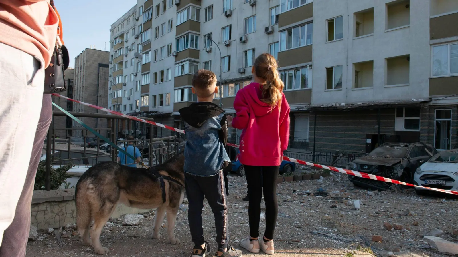 Kriegsalltag: Kinder schauen in Kiew auf ein bei russischen Raketenangriffen beschädigtes Gebäude. (Foto: Danylo Antoniuk/ZUMA Press Wire/dpa)