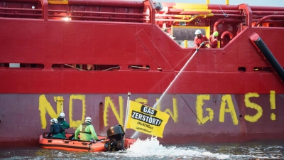 Greenpeace-Aktivisten mit einem Schlauchboot vor einem Schiff im Hafen von Mukran. (Foto: Gregor Fischer/Greenpeace Germany/dpa)