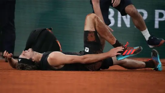 Alexander Zverev liegt nach seiner Verletzung bei den French Open am Boden. (Foto: Christophe Ena/AP/dpa)
