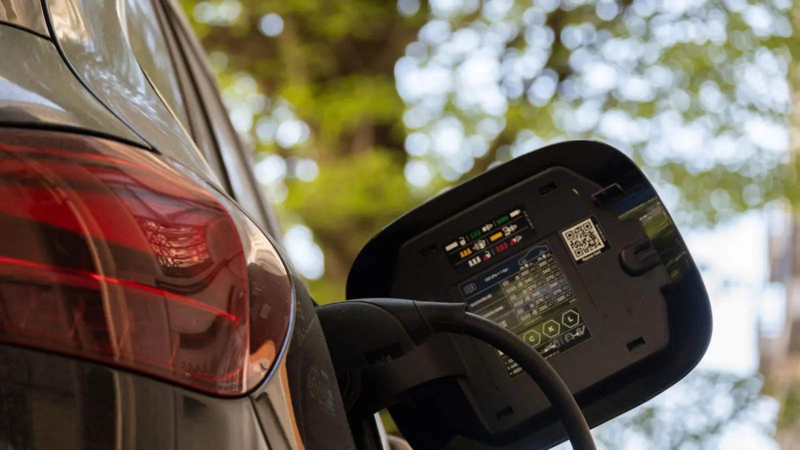 Ein E-Auto an einer Ladesäule. Im zweiten Quartal haben sich laut „E-Barometer“ der HUK Coburg so viele private Autokäufer für ein E-Auto entschieden wie seit Streichung des „Umweltbonus“ Ende 2023 nicht mehr. (Symbolbild)  (Foto: Anna Ross/dpa)