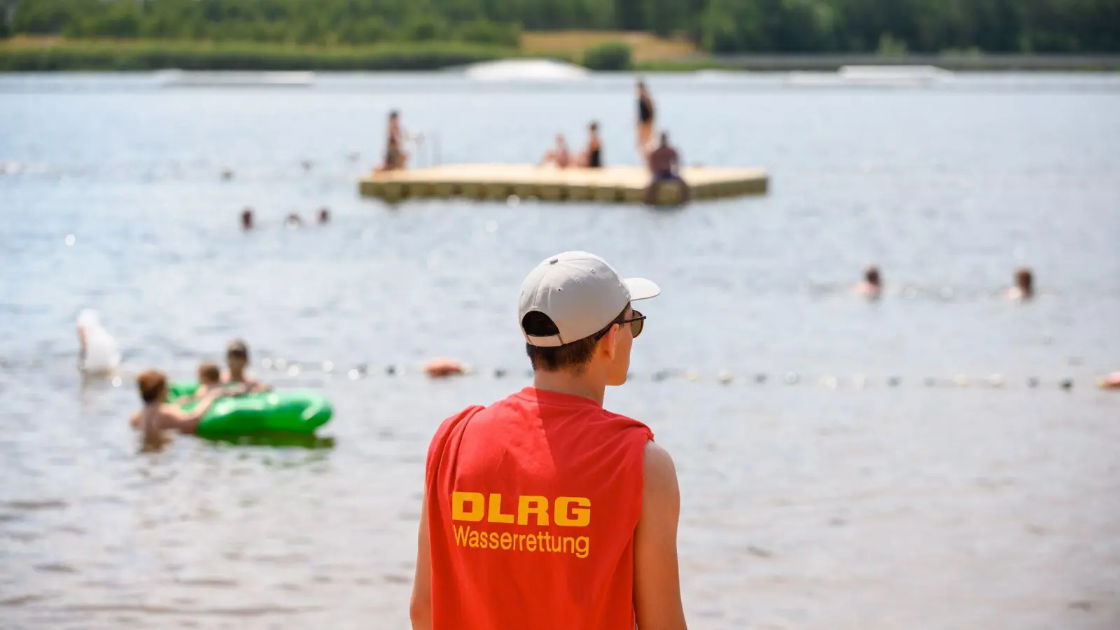 Ein Mitglied der Deutschen Lebens-Rettungs-Gesellschaft (DLRG) steht in einem Strandbad am Ufer. (Foto: Jonas Walzberg/dpa/Symbolbild)