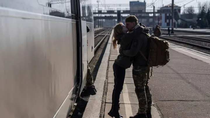 Auf dem Bahnhof im ukrainischen Kramatorsk küsst ein ukrainischer Soldat seine Partnerin. Präsident Wolodymyr Selenskyj hat nach einem Besuch der Frontgebiete im Osten des Landes von großem Leid, aber auch von Hoffnung gesprochen. (Foto: Evgeniy Maloletka/AP)