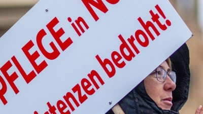 Bei einer Protestaktion vor dem Schweriner Landtag hält eine Teilnehmerin ein Schild mit der Aufschrift „Pflege in Not - Existenzen bedroht!“. (Foto: Jens Büttner/dpa)