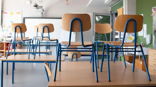 Stühle stehen in einem Klassenzimmer auf den Tischen. (Foto: Sebastian Kahnert/dpa-Zentralbild/dpa/Symbolbild)