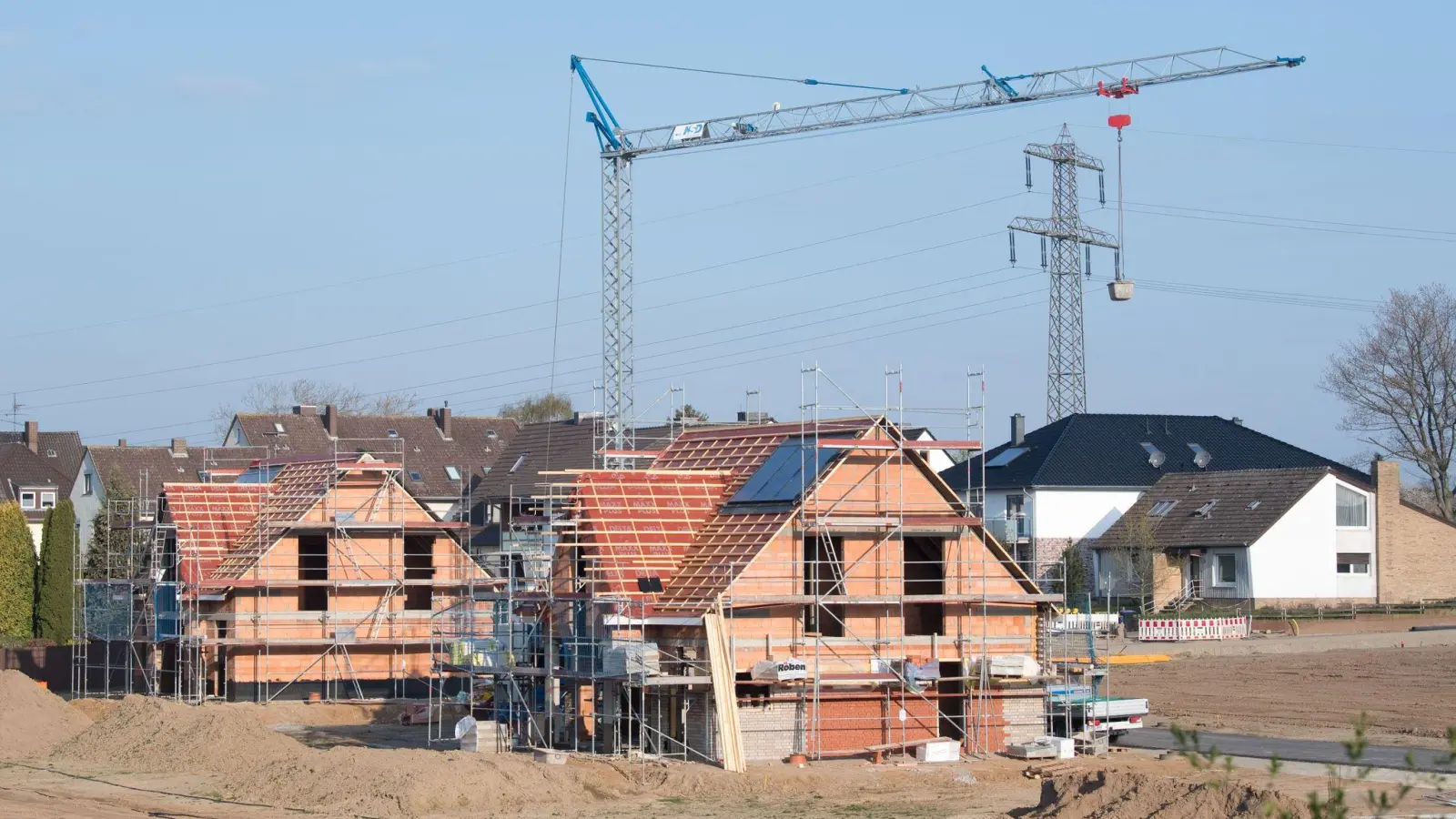 Einfamilienhäuser stehen im Rohbau in einem Neubaugebiet.Die Zahl der Baugenehmigungen ist in den ersten drei Monaten des laufenden Jahres gesunken. (Foto: Julian Stratenschulte/dpa)