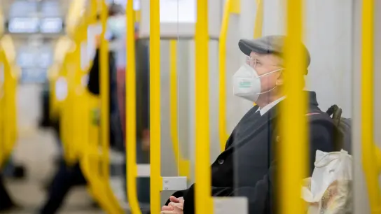 Ein Mann sitzt mit FFP2-Maske in einer U-Bahn. (Foto: Christoph Soeder/dpa/Symbolbild)
