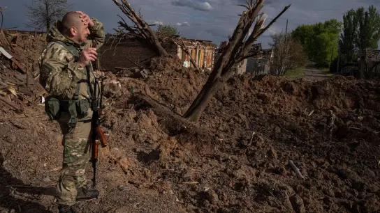 Ein ukrainischer Soldat inspiziert nach einem russischen Luftangriff in Bachmut das Terrain. (Foto: Evgeniy Maloletka/AP/dpa)