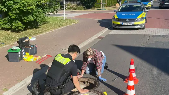 Polizisten inspizieren einen Gully - der Junge wurde hier nach mehr als einer Woche wiedergefunden. (Foto: Andre van Elten/dpa)